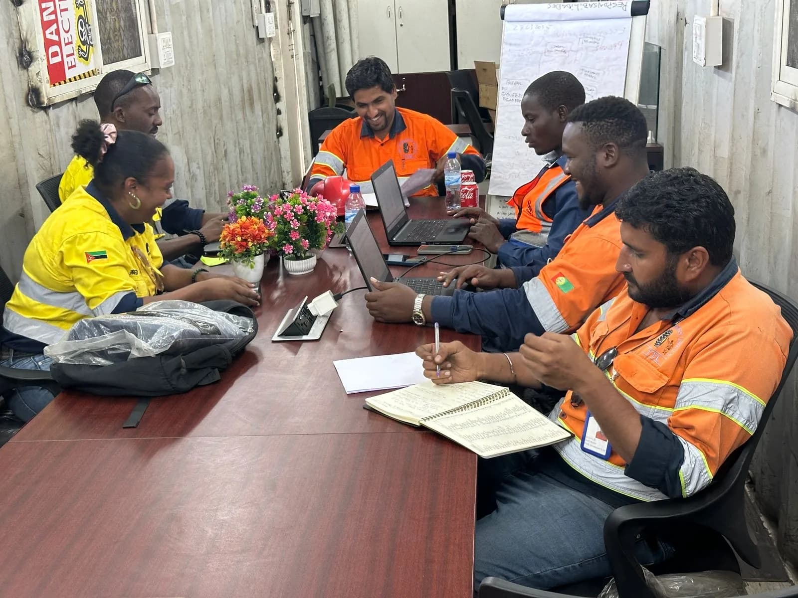 Equipa reunida à mesa com computadores e apontamentos