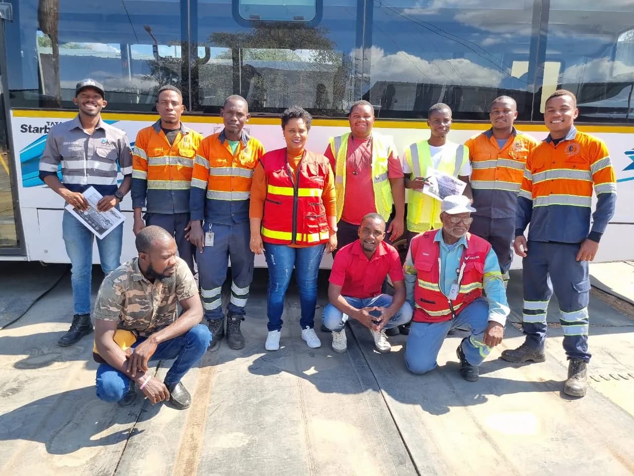 Equipa com vestuário refletor junto a um autocarro