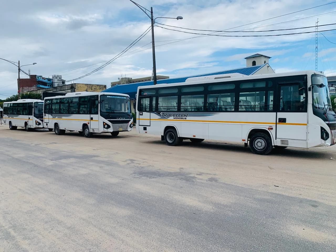 Autocarros de passageiros estacionados em fila junto a uma rua