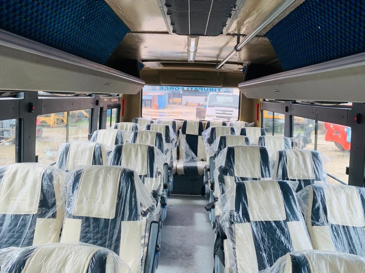 Interior de autocarro com bancos revestidos em plástico e corredor central