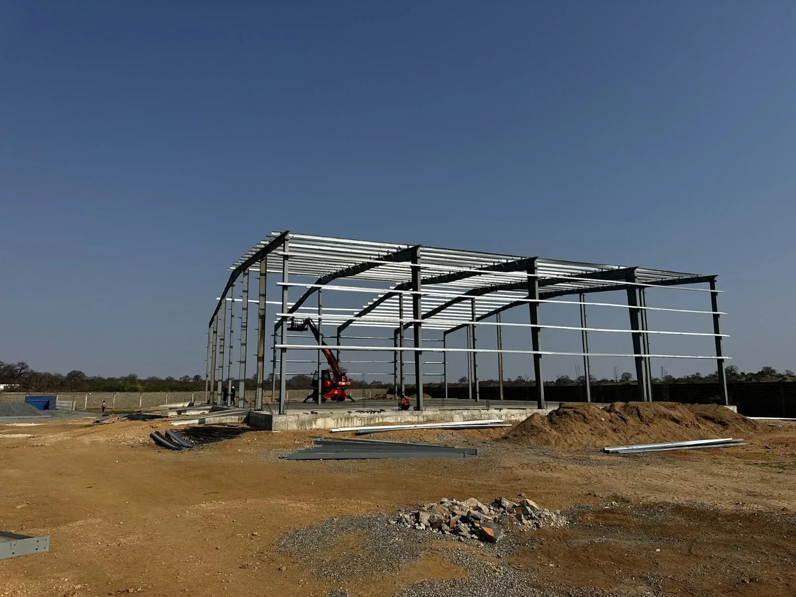 Vista geral de uma estrutura metálica em montagem num terreno de obras